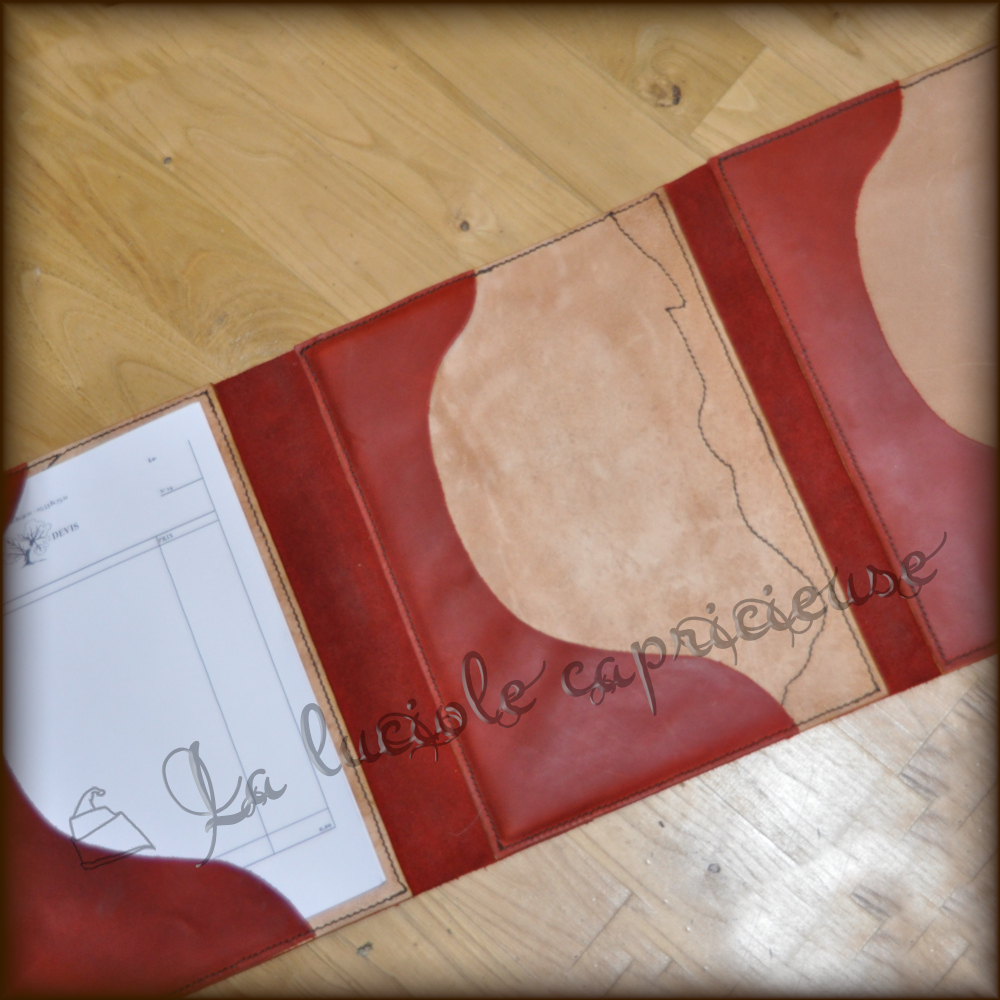 Intérieur d'un facturier en cuir de bovin, avec feuilles de papiers maintenues par des rabats en cuir cousus main