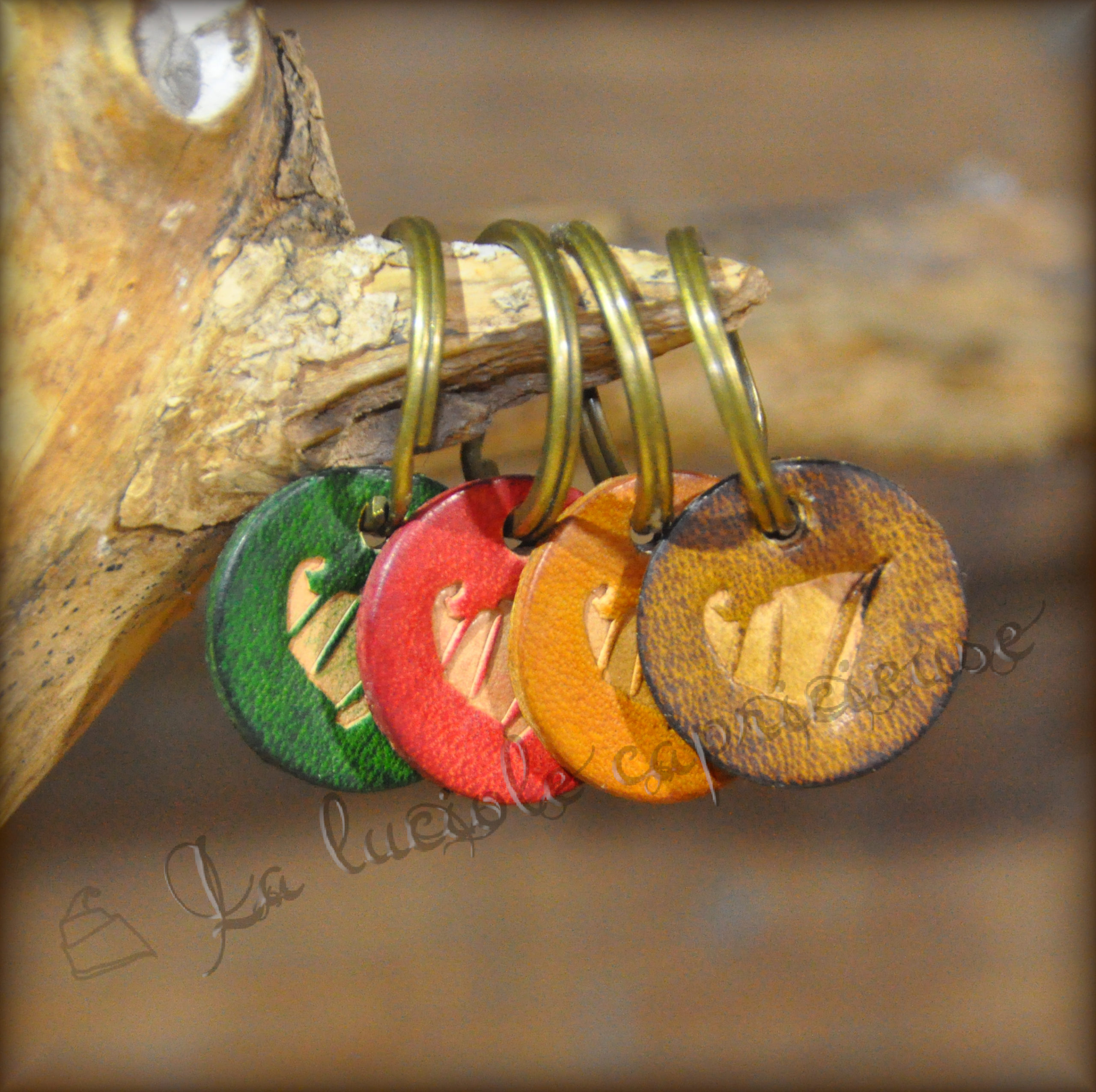 Lot de quatre porte-clés en cuir de bovin tanné végétal, logo en relief, teintés de plusieurs couleurs
