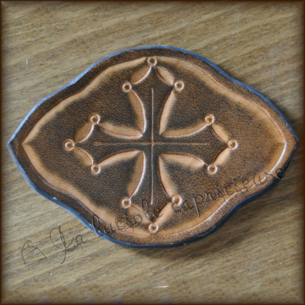 Médaillon en cuir de bovin tanné végétal, motif en relief croix occitane, teinté marron