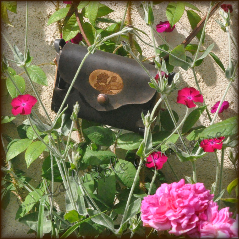 Petite sacoche en cuir tanné végétal faite main par La luciole capricieuse, entourée de fleurs